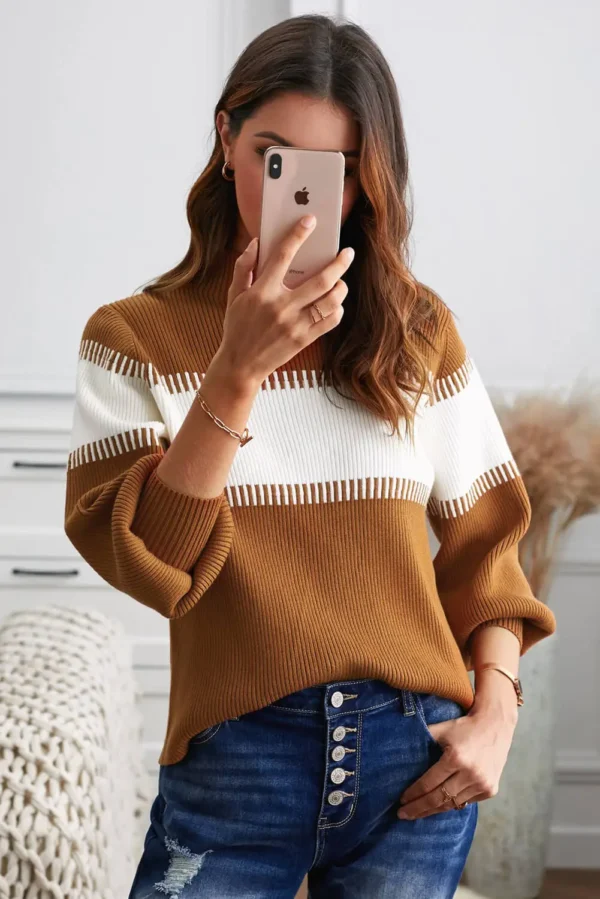 Women in light brown and white sweater holding cell phone
